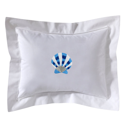 White pillow with blue and white shell design on a white background