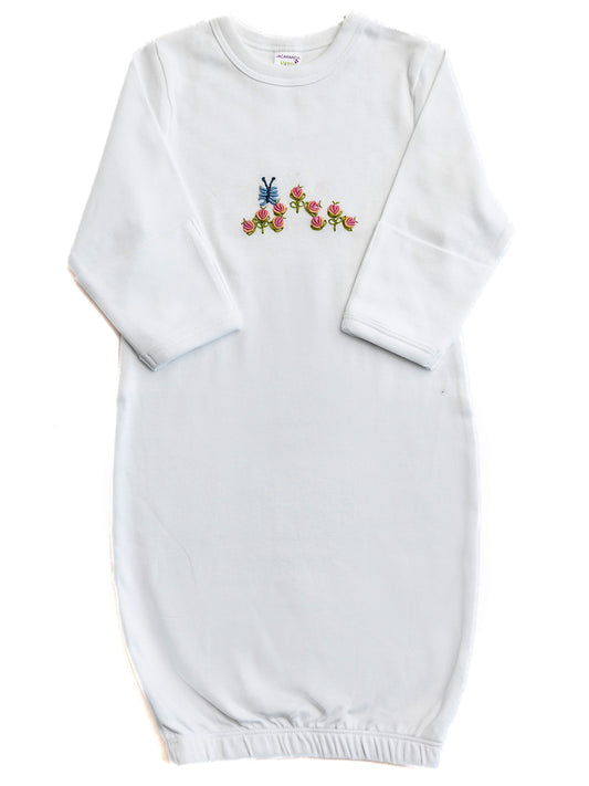 White baby gown with colorful floral embroidery on a white background