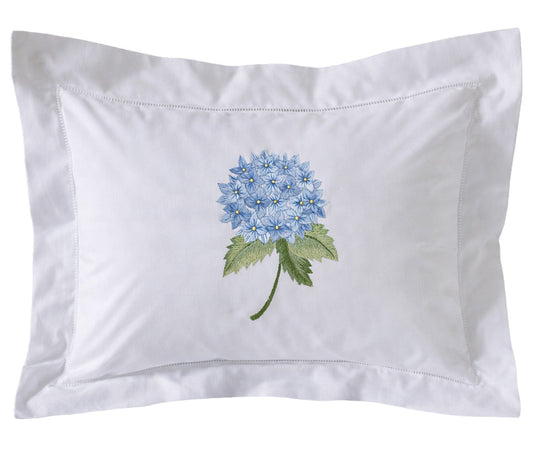 White pillow with embroidered blue flower design on a white background