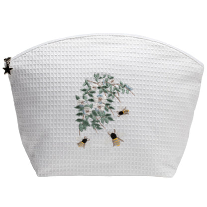 White textured pouch with floral and bee design on a white background