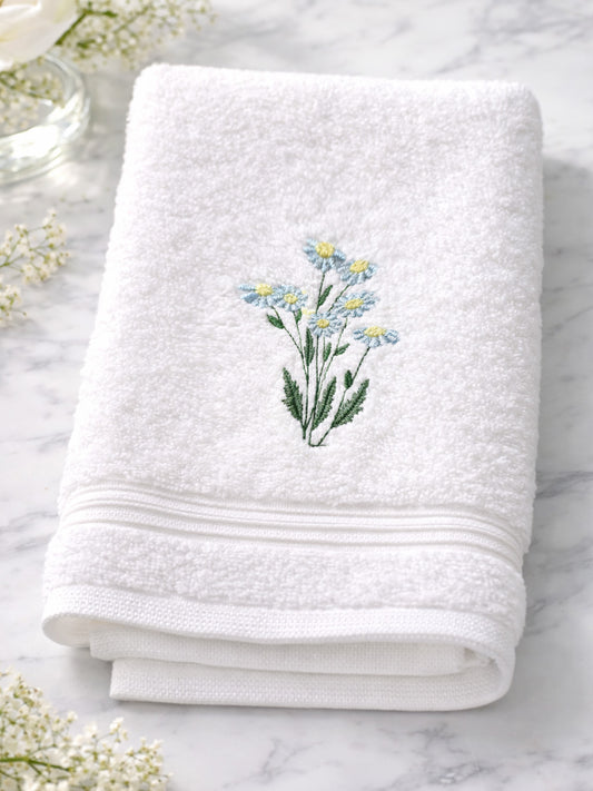 White towel with floral embroidery on a marble surface