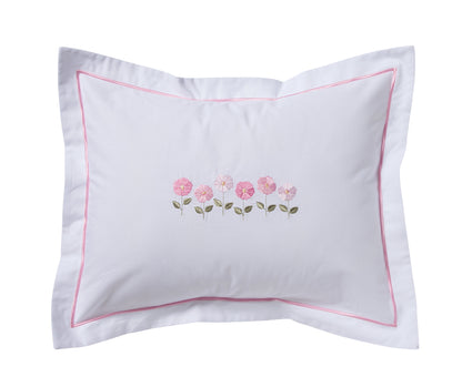 A white pillow sham featuring a delicate pink embroidered floral motif in the center and a thin pink border trim, shown against a plain white background.