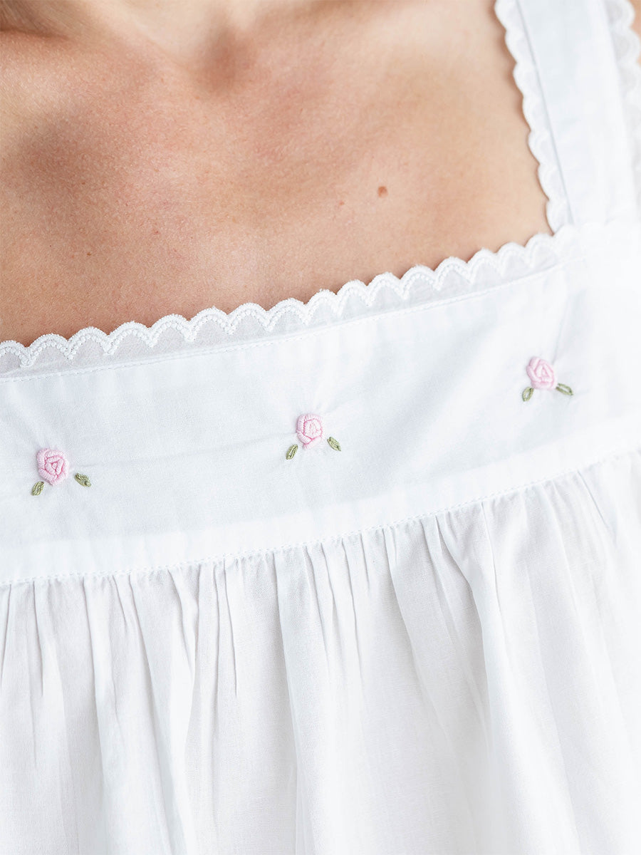 White top with floral embroidery on a plain background