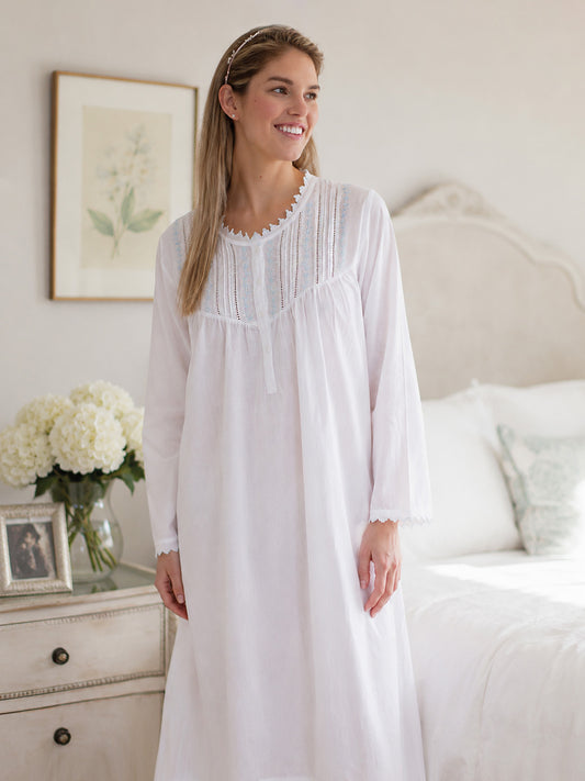 Woman wearing a white nightgown in a bedroom setting