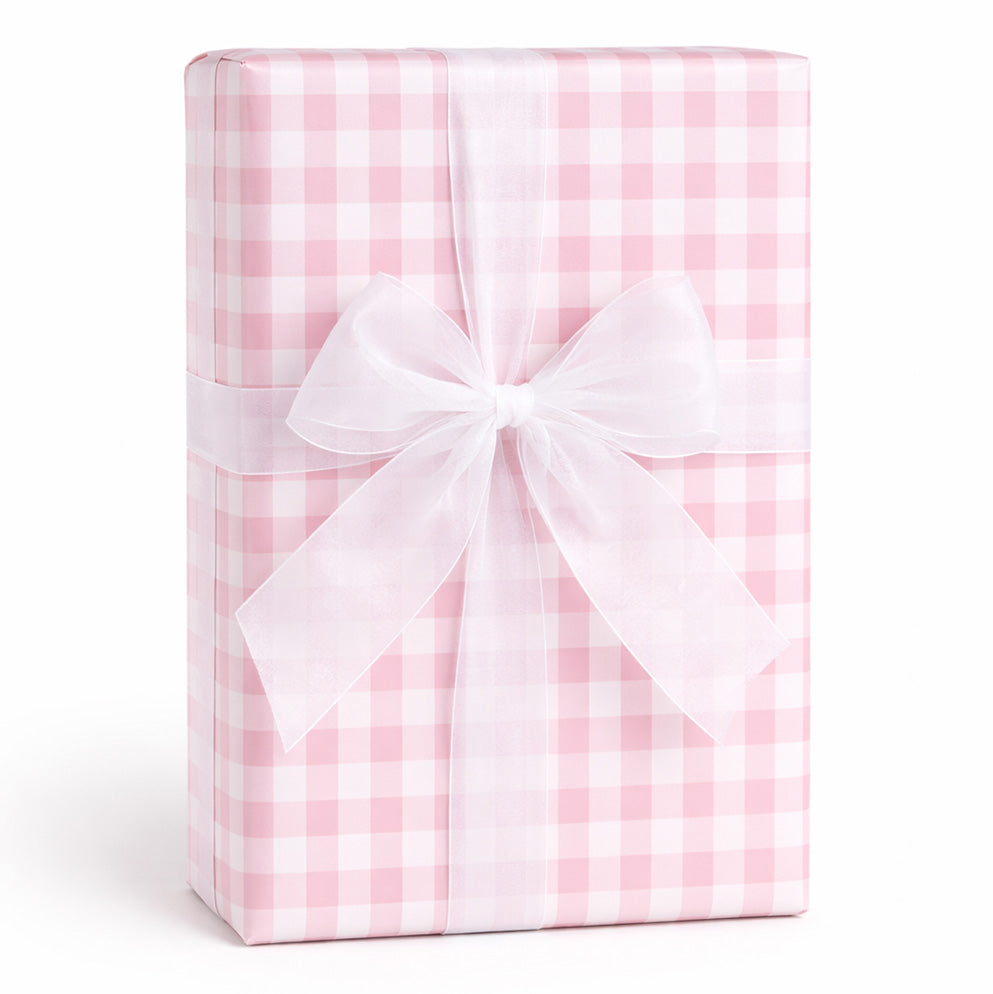 Gift box wrapped in pink and white checkered paper with a white bow on a white background