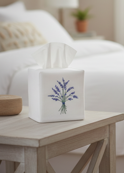 Two tissue boxes with floral designs on a nightstand and chair in a bedroom.