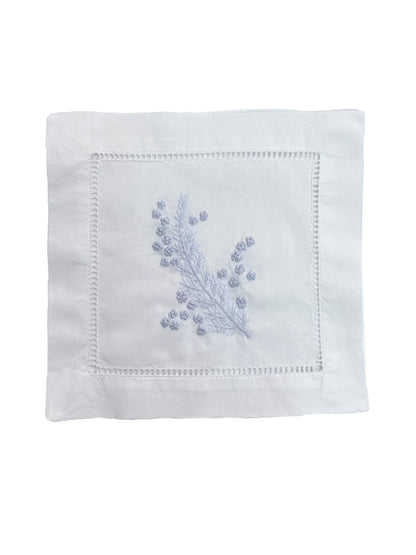 White napkin with blue floral embroidery on a white background